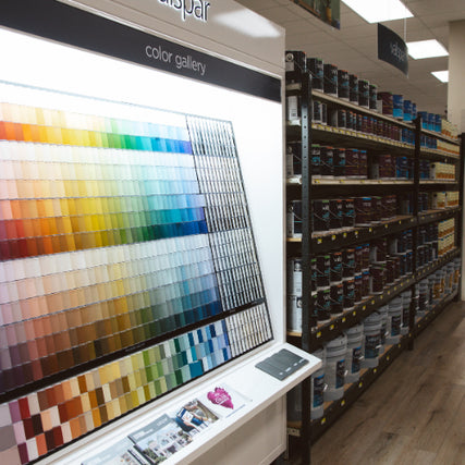 Paint & SuppliesA paint store display shows a vibrant color gallery with various paint swatches. To the right, shelves are stocked with multiple paint cans.